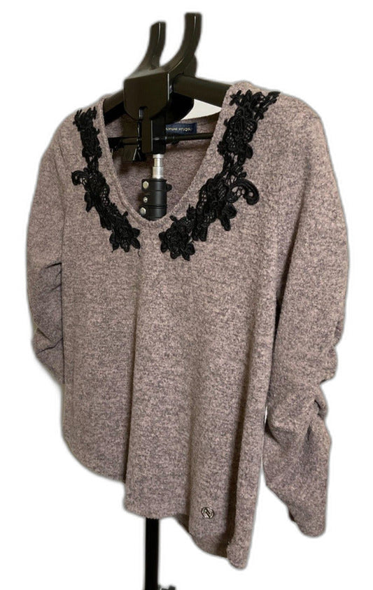 A taupe knit sweater with black lace trim around the scoop neckline, displayed on a black hanger stand against a white background.