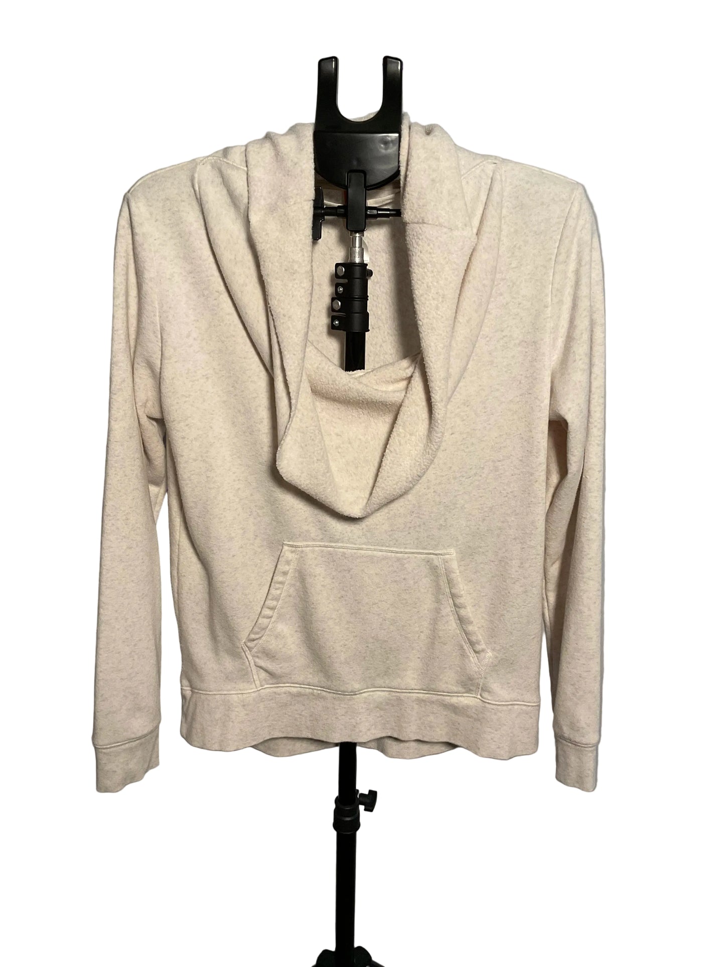 A light beige heathered cowl neck pullover hoodie with a front kangaroo pocket, displayed on a black hanger stand against a gray studio background.