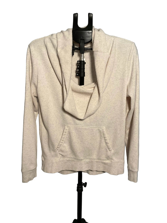 A light beige heathered cowl neck pullover hoodie with a front kangaroo pocket, displayed on a black hanger stand against a gray studio background.