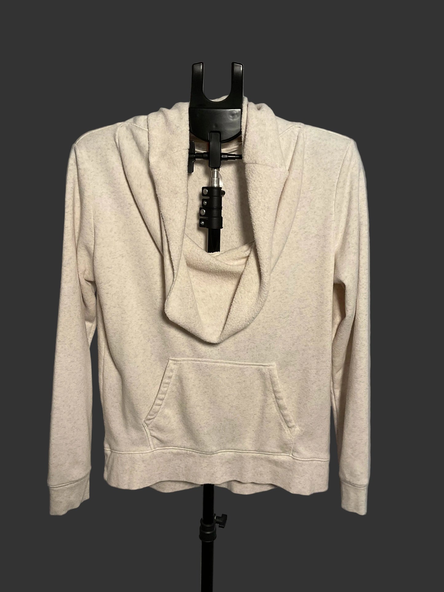 A light beige heathered cowl neck pullover hoodie with a front kangaroo pocket, displayed on a black dress form stand against a gray background.