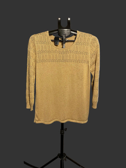 A mustard yellow knit sweater with a textured yoke pattern, displayed on a black hanger stand against a white circular studio backdrop.