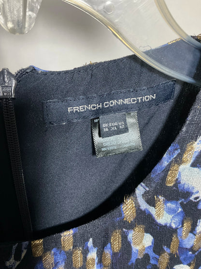 Close-up of the inside neckline of a French Connection garment, showing the brand label and a size tag reading 18 XL, with a blue, black, and gold patterned fabric visible.