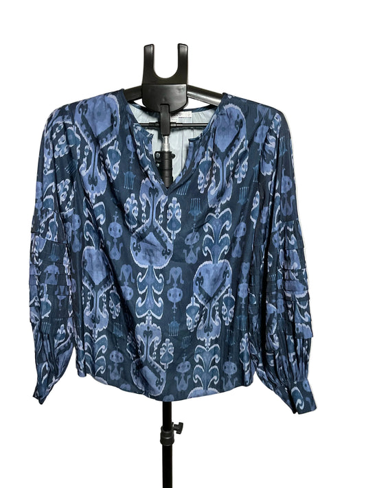 A blue and navy patterned blouse with long sleeves and a V-neckline, displayed on a black hanger stand against a plain light background.