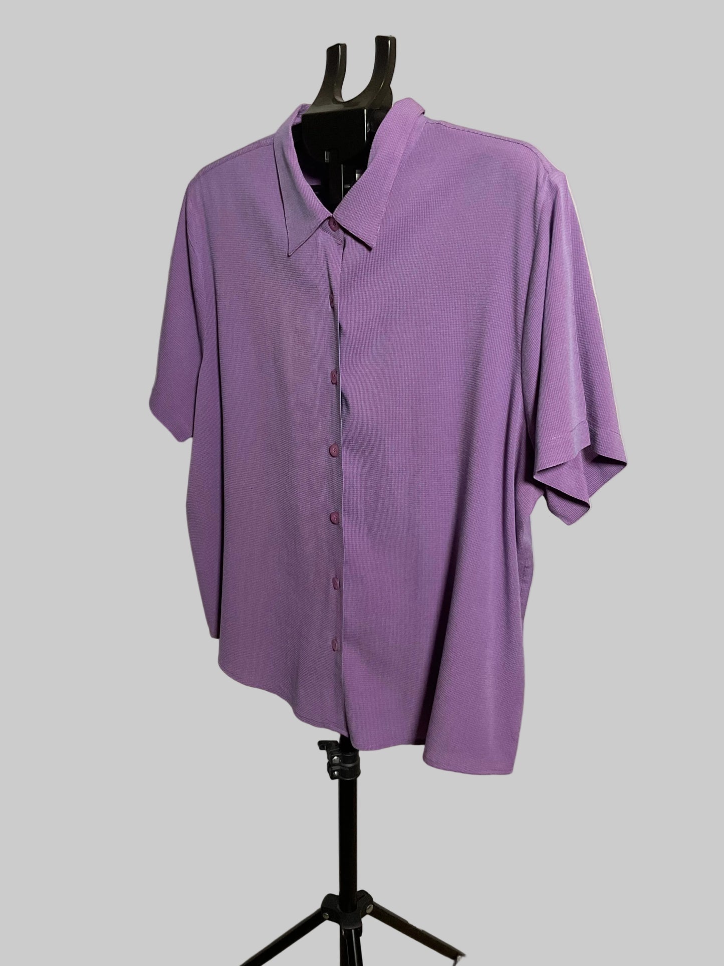 A lavender purple short-sleeve button-up shirt displayed on a black dress form mannequin stand against a white studio backdrop.