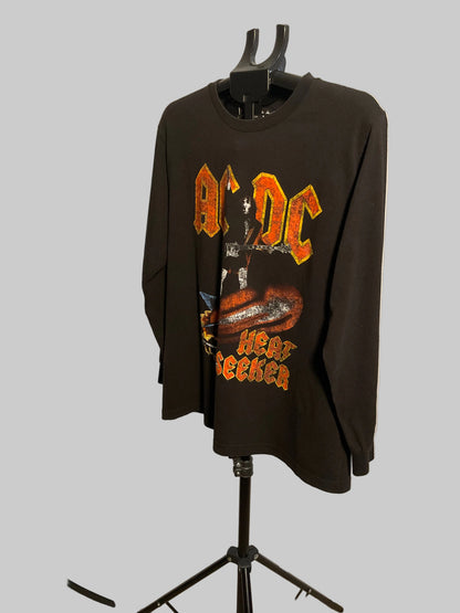 A black long-sleeve AC/DC 'Hair Meeker' graphic t-shirt displayed on a black hanger stand against a white studio backdrop.