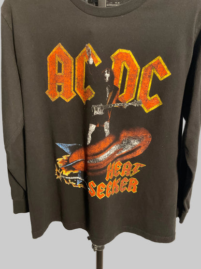 A black long-sleeve AC/DC 'Hair on Fire' graphic t-shirt displayed on a black hanger against a light gray wall.