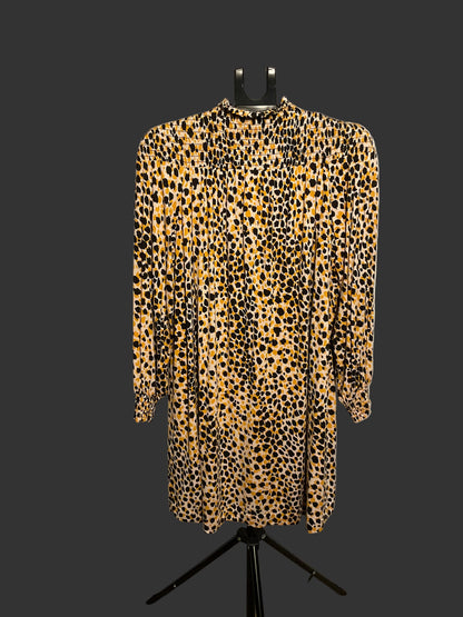 A leopard print long-sleeve dress displayed on a black hanger stand in front of a large white circular backdrop.