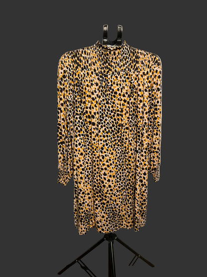 A leopard print long-sleeve shirt dress displayed on a black hanger stand in front of a white circular backdrop.