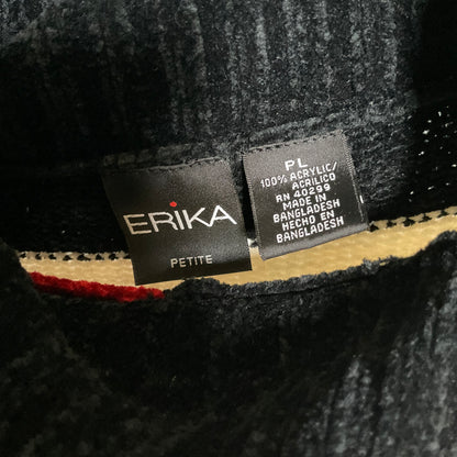 Close-up of a black textured knit garment showing two interior brand labels. The left label reads ERIKA PETITE, and the right label reads PL 100% ACRYLIC/ACRILICO RN 60299 MADE IN BANGLADESH RECHO EN BANGLADESH.