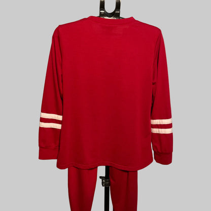 A red long-sleeve athletic top and matching red pants displayed on a hanger stand against a plain light background. The sleeves have two horizontal white stripes near the cuffs.