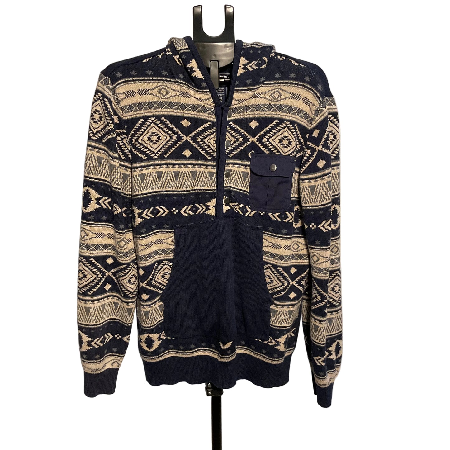 A navy blue and cream patterned zip-up hoodie with a hood, chest pocket, and front pockets, displayed on a black hanger against a plain light background.
