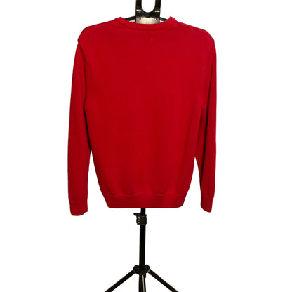 A bright red crewneck sweatshirt displayed on a black hanger stand against a white circular backdrop.