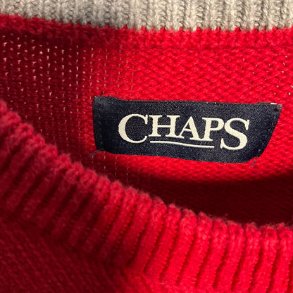 Close-up of a red knit sweater with a black CHAPS brand label sewn onto the inside collar, with a light beige ribbed knit band visible at the top.