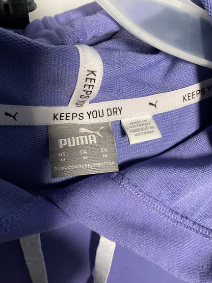 Close-up of a purple Puma hoodie showing the inner neck label, white Puma branding tape, and a gray Puma brand tag.