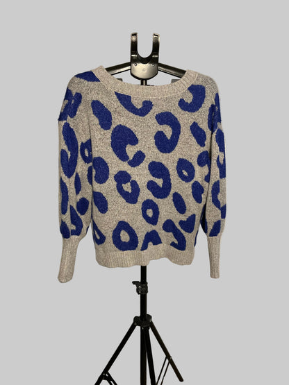 A gray knit sweater with a bold blue leopard print pattern, displayed on a black hanger stand against a white circular studio backdrop.