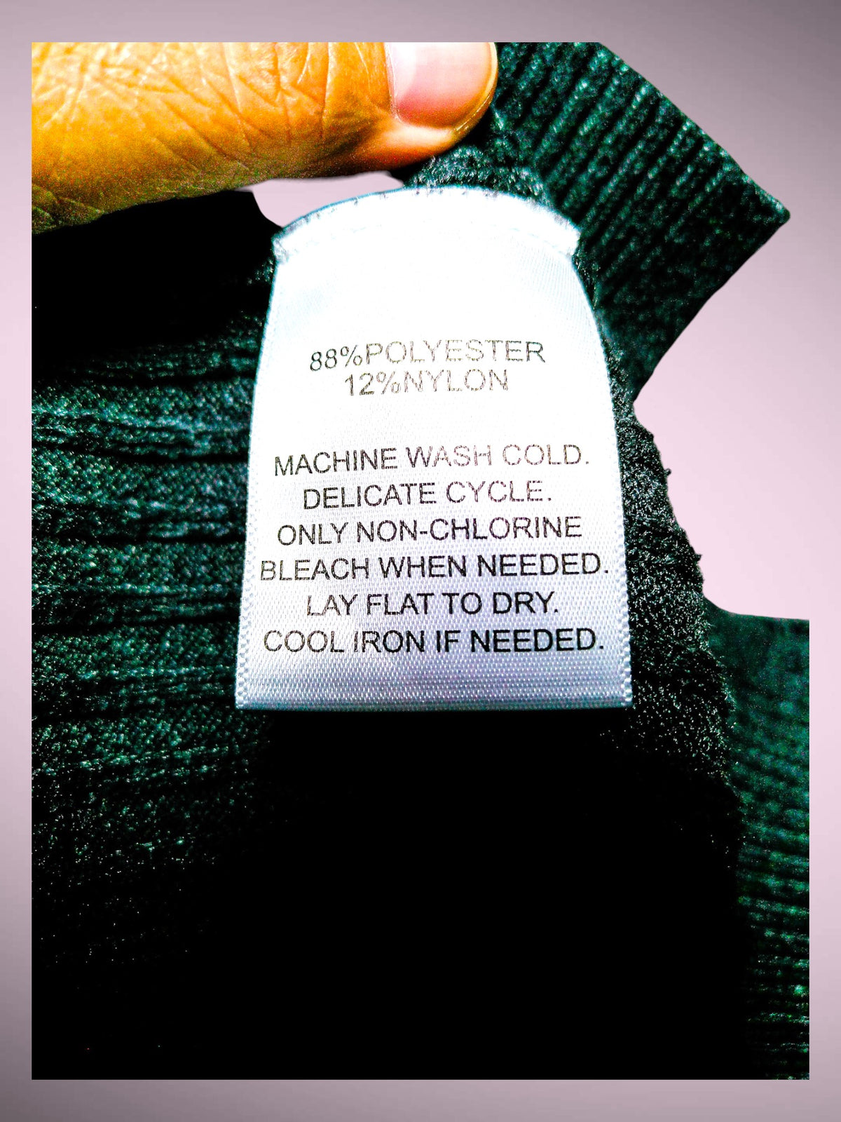 Calligraphy sweater care label showing polyester and nylon blend