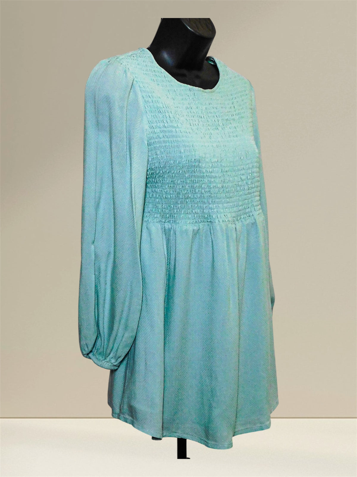 Angled front view showing the smocked bodice and flowing hem of the blue maternity top