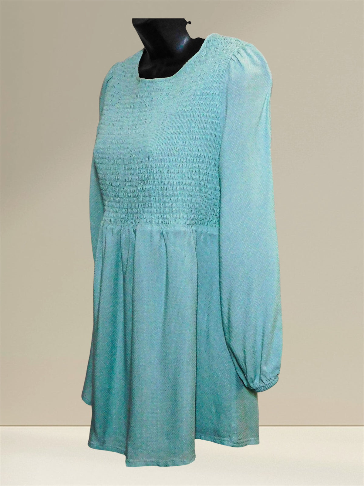 Opposite angled view showing long sleeve and elastic cuff of the blue maternity top