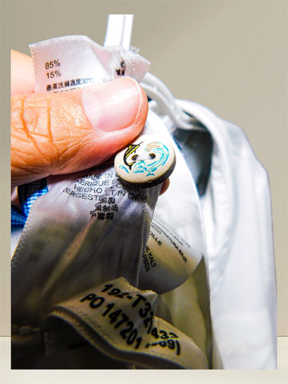 Close-up of decorative marlin and wave button detail