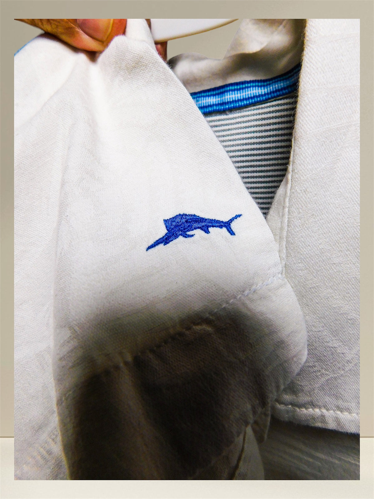 Close-up of embroidered blue marlin logo on sleeve
